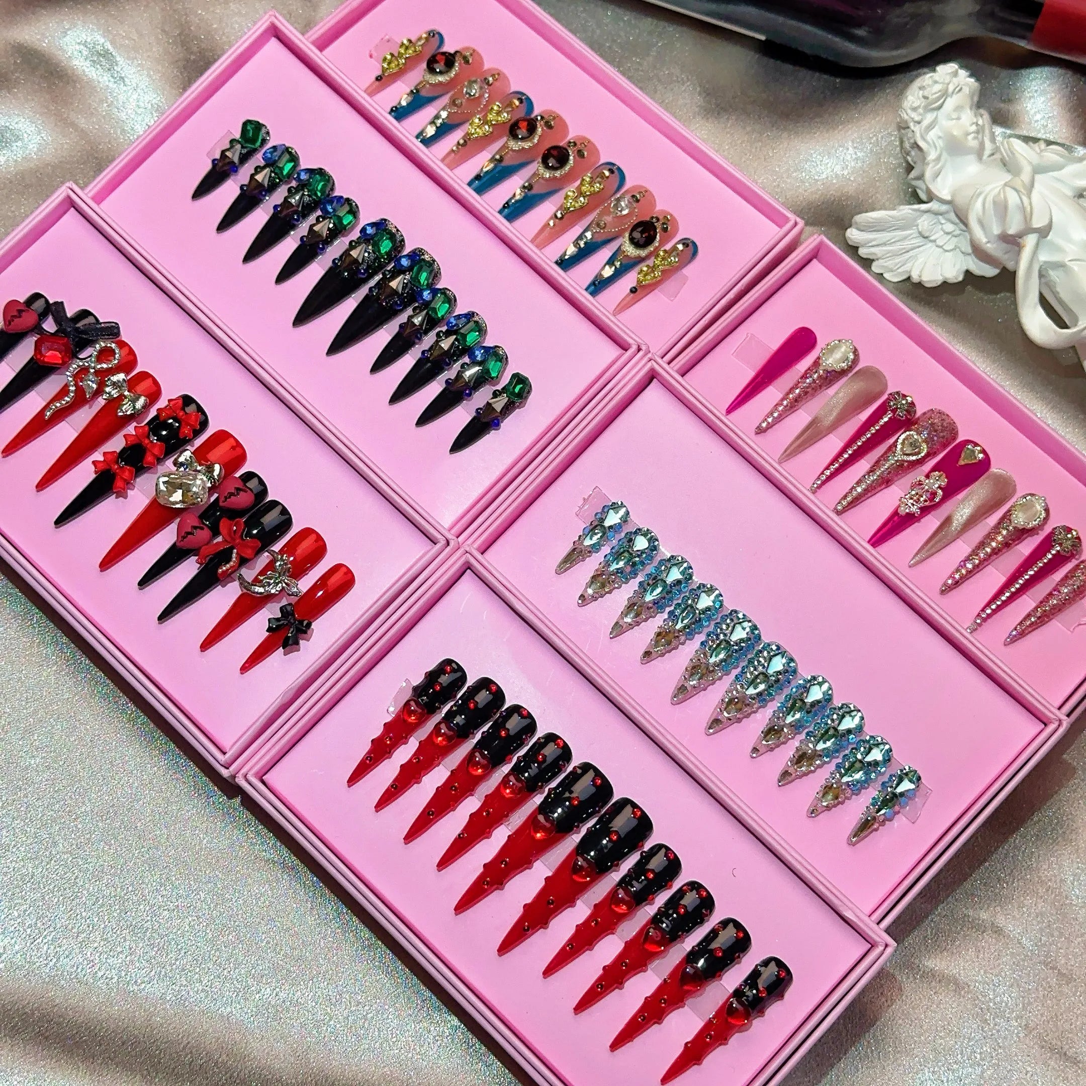 Ongles press-on en acrylique faits main, design de créateur avec strass, forme amande, longueur longue, livrés avec colle, emballage personnalisé.