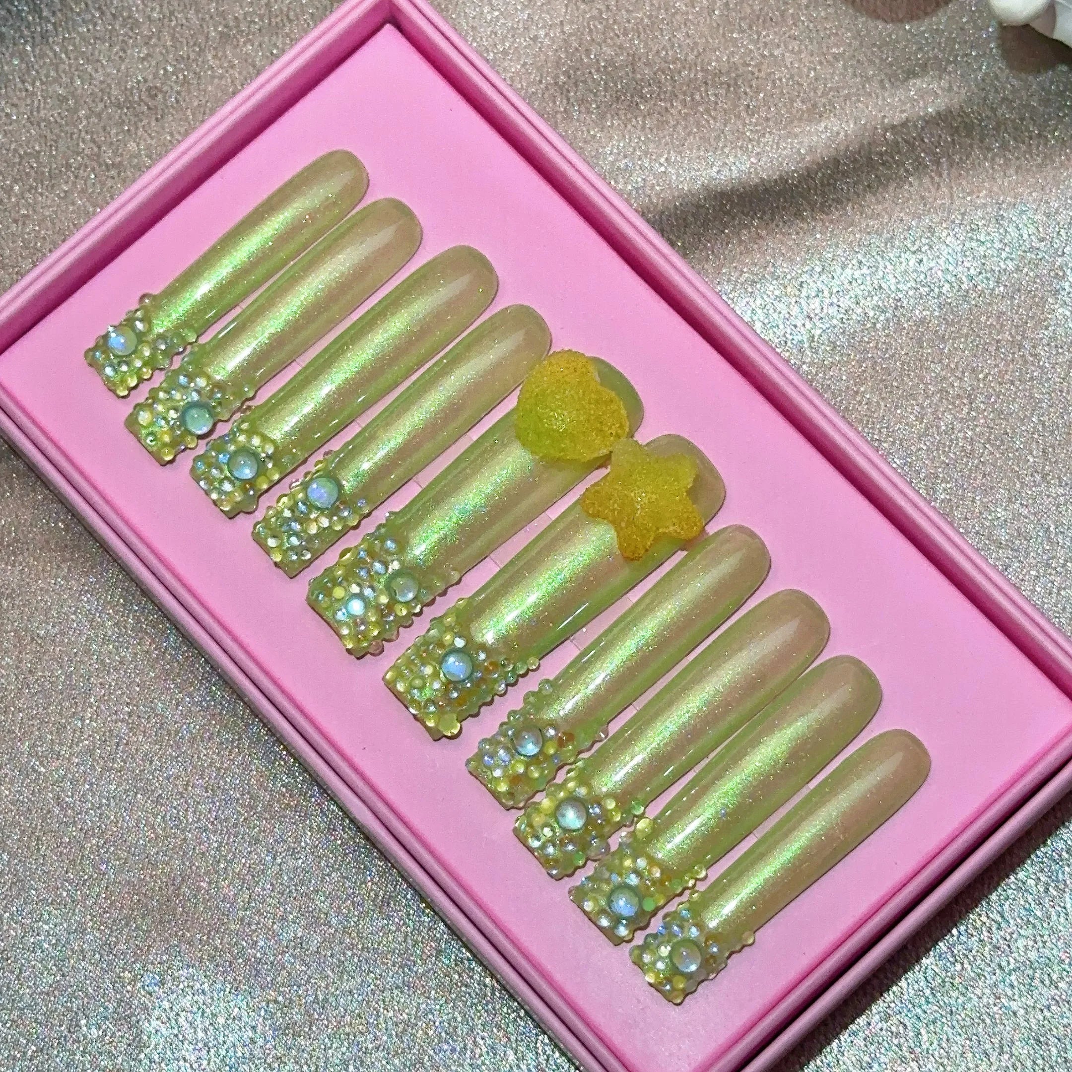 Ongles press-on en acrylique faits main, design de créateur avec strass, forme amande, longueur longue, livrés avec colle, emballage personnalisé.