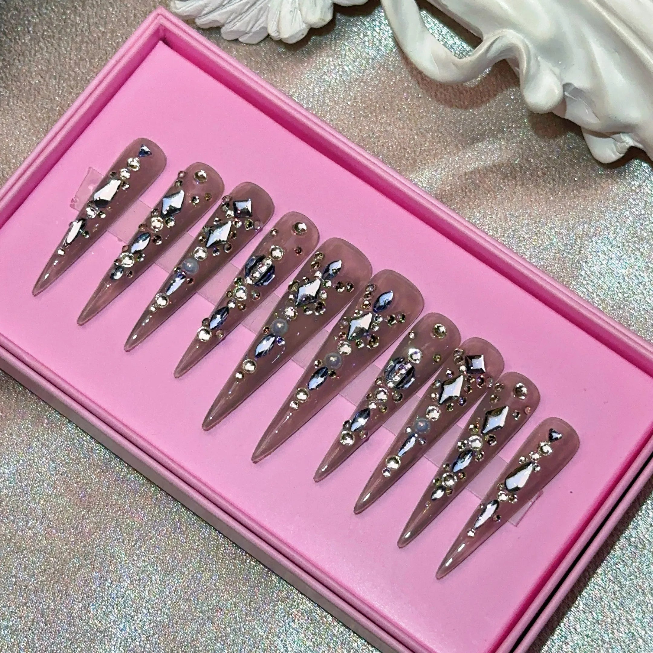 Ongles press-on en acrylique faits main, design de créateur avec strass, forme amande, longueur longue, livrés avec colle, emballage personnalisé.