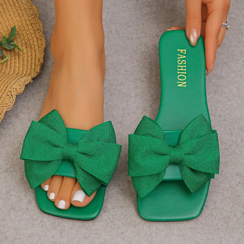 Nouvelles mules plates pour femme 2026, sandales tendance à couleur unie avec nœud décoratif, légères et confortables pour l’extérieur, la plage et un usage quotidien. Disponibles en grandes tailles.
