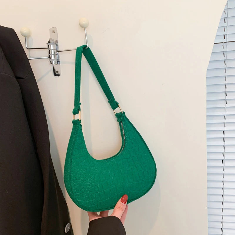 Sac tendance en feutre de haute qualité, au style rétro et élégant. Conçu pour être porté sous le bras ou à l’épaule, il allie simplicité et design moderne.
