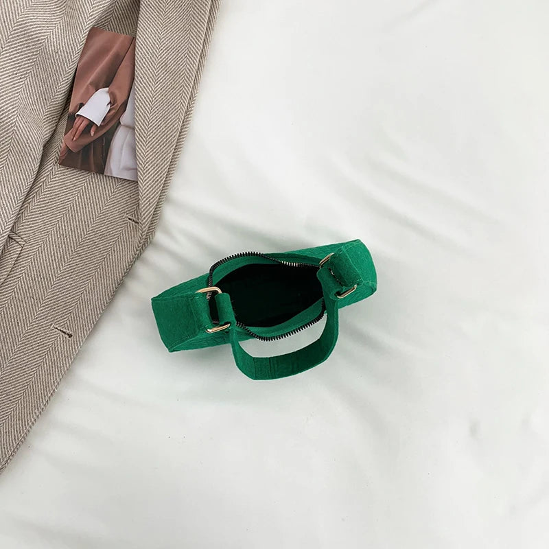 Sac tendance en feutre de haute qualité, au style rétro et élégant. Conçu pour être porté sous le bras ou à l’épaule, il allie simplicité et design moderne.