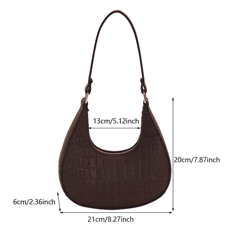 Sac tendance en feutre de haute qualité, au style rétro et élégant. Conçu pour être porté sous le bras ou à l’épaule, il allie simplicité et design moderne.