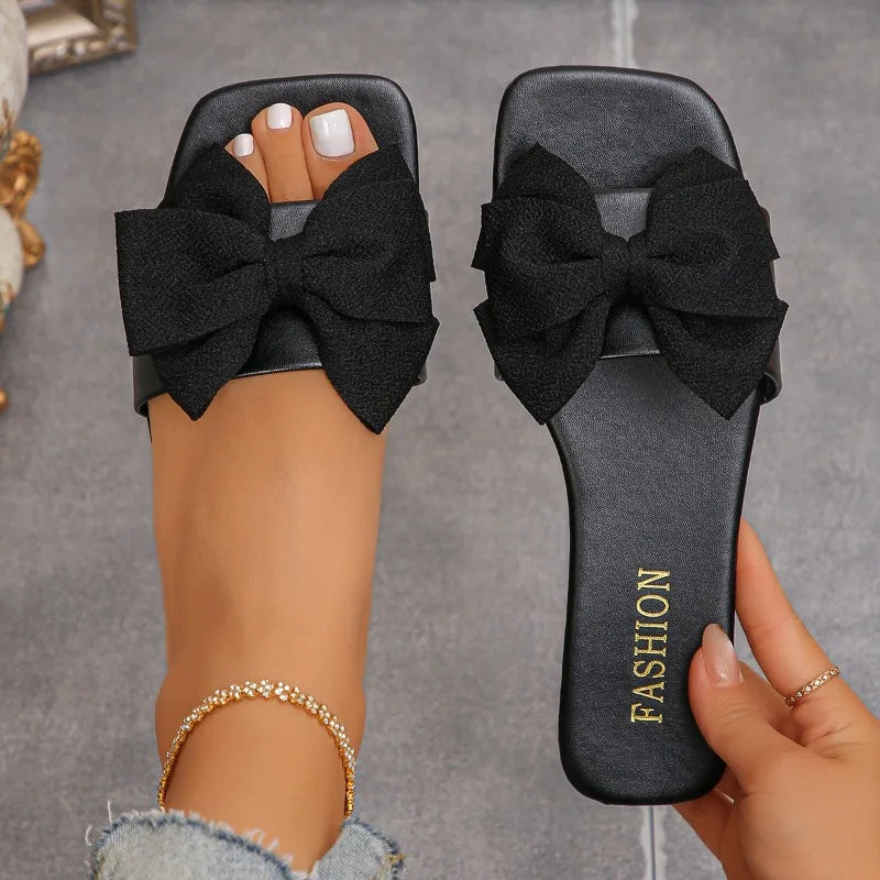 Nouvelles mules plates pour femme 2026, sandales tendance à couleur unie avec nœud décoratif, légères et confortables pour l’extérieur, la plage et un usage quotidien. Disponibles en grandes tailles.