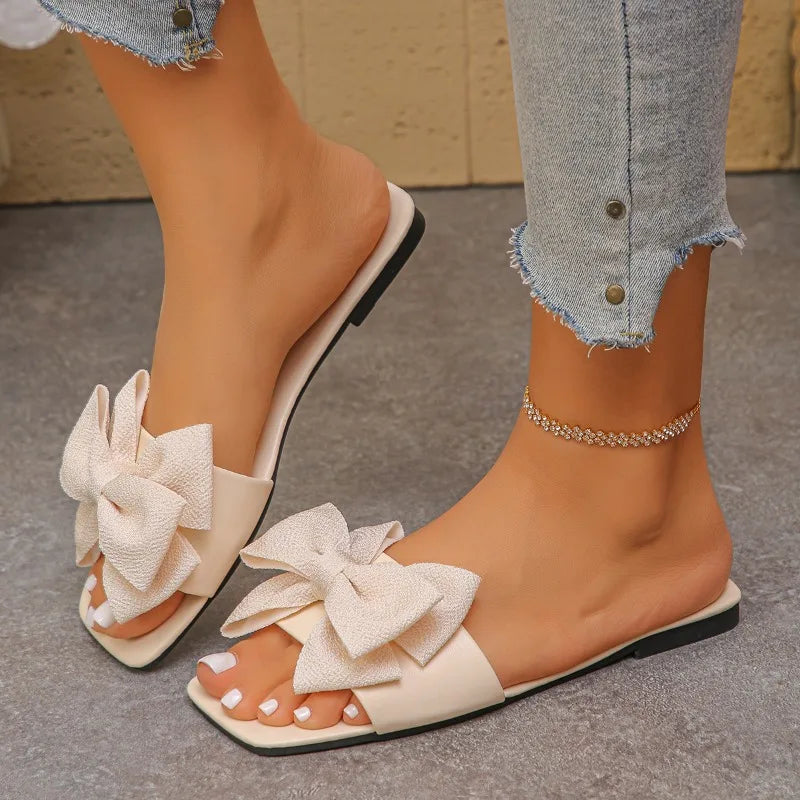 Nouvelles mules plates pour femme 2026, sandales tendance à couleur unie avec nœud décoratif, légères et confortables pour l’extérieur, la plage et un usage quotidien. Disponibles en grandes tailles.