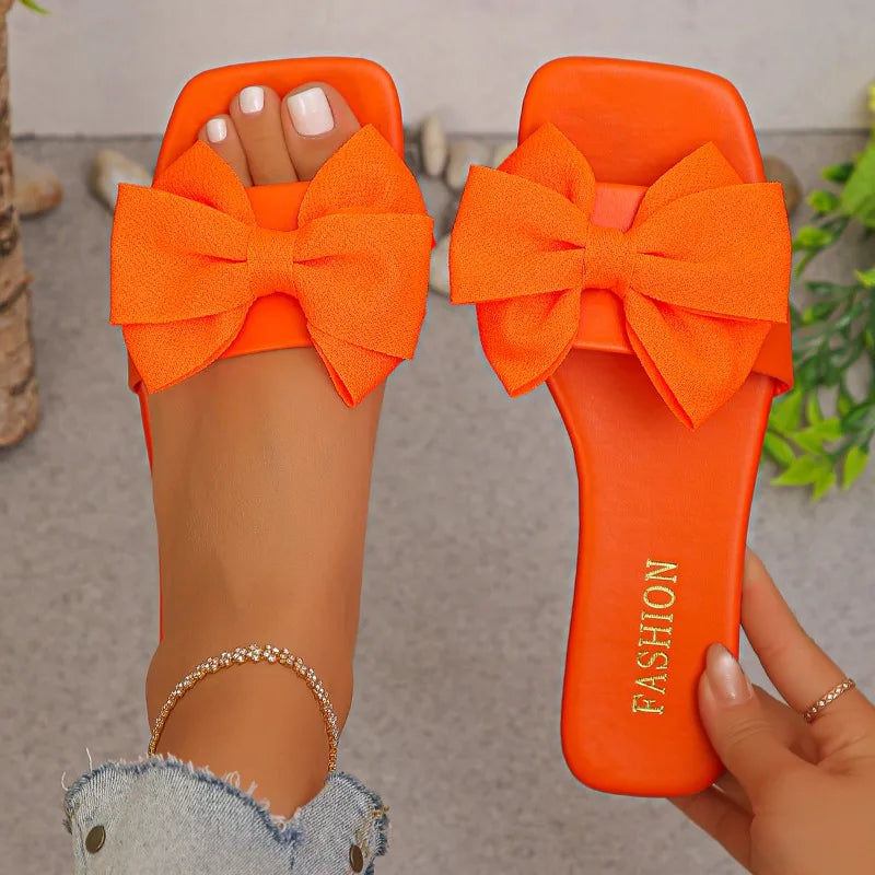 Nouvelles mules plates pour femme 2026, sandales tendance à couleur unie avec nœud décoratif, légères et confortables pour l’extérieur, la plage et un usage quotidien. Disponibles en grandes tailles.