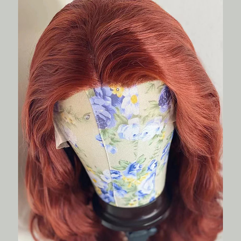Perruque synthétique à ondulations souples (Body Wave) avec lace frontale, sans colle (glueless). Coloration brun roux cuivré (Auburn/Copper Red) pour un effet naturel et lumineux.