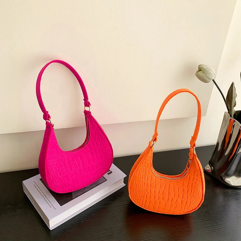 Sac tendance en feutre de haute qualité, au style rétro et élégant. Conçu pour être porté sous le bras ou à l’épaule, il allie simplicité et design moderne.