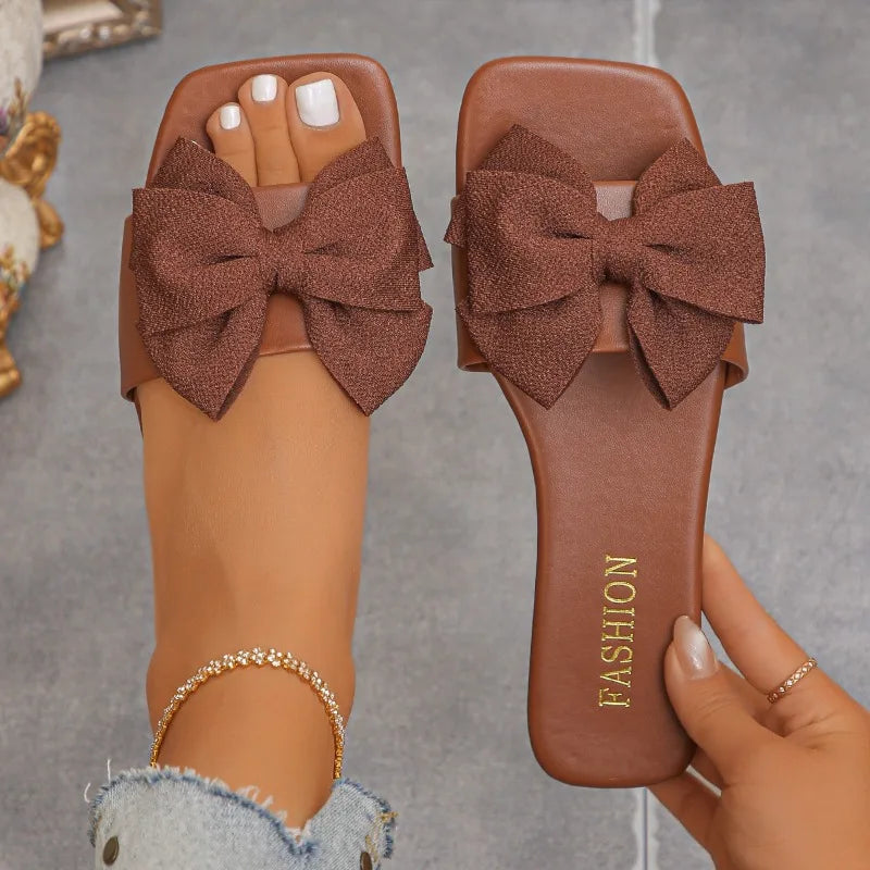 Nouvelles mules plates pour femme 2026, sandales tendance à couleur unie avec nœud décoratif, légères et confortables pour l’extérieur, la plage et un usage quotidien. Disponibles en grandes tailles.