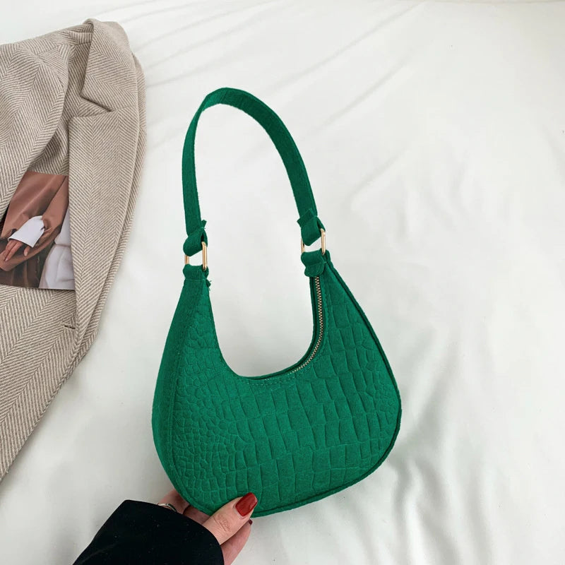 Sac tendance en feutre de haute qualité, au style rétro et élégant. Conçu pour être porté sous le bras ou à l’épaule, il allie simplicité et design moderne.