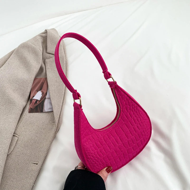 Sac tendance en feutre de haute qualité, au style rétro et élégant. Conçu pour être porté sous le bras ou à l’épaule, il allie simplicité et design moderne.