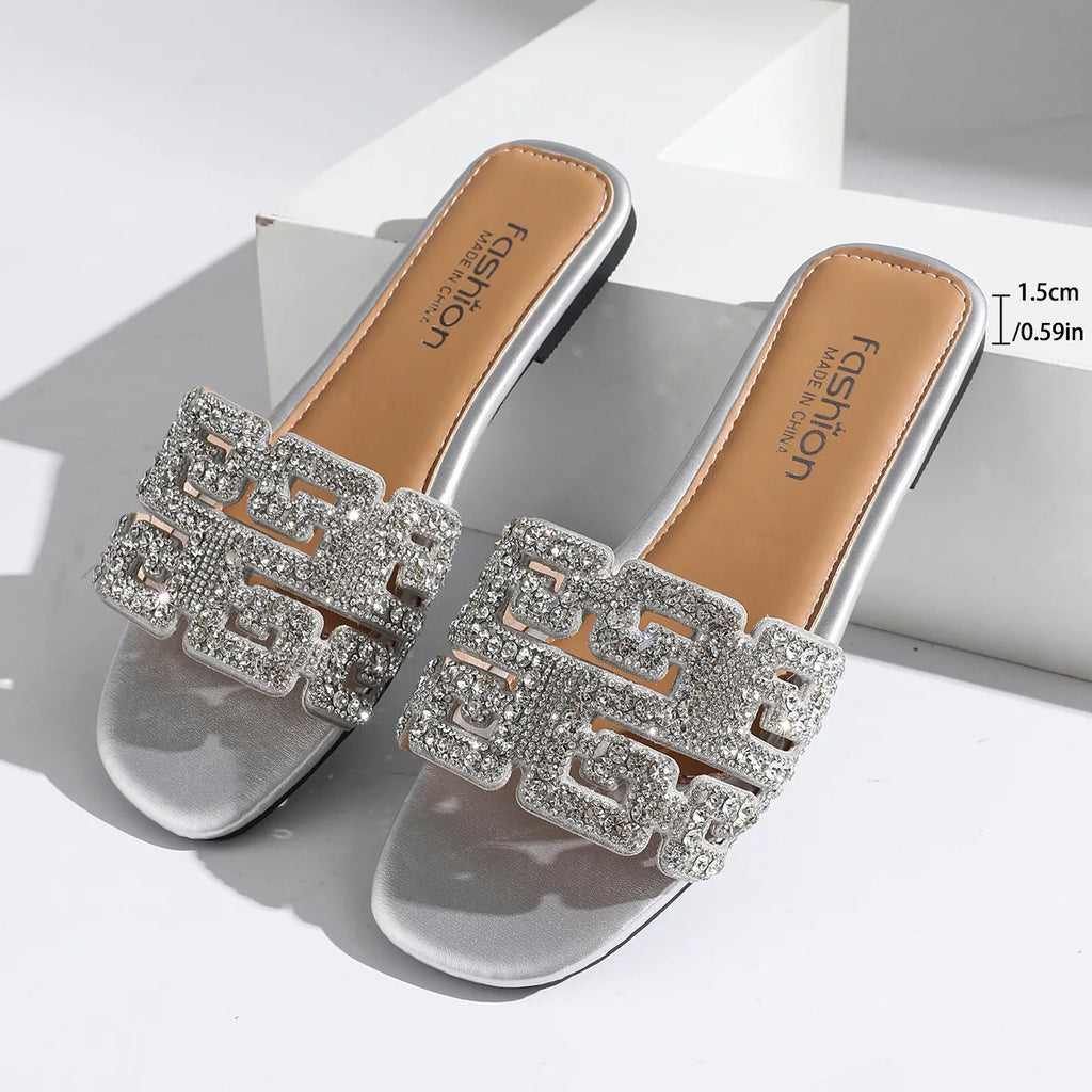 Sandales d’été 2026 pour femme à semelle plate, avec motif géométrique et décorations en diamant. Chaussures de plage polyvalentes et décontractées à enfiler, au style tendance et moderne pour femme.