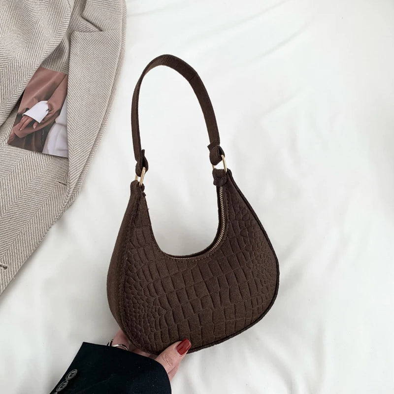 Sac tendance en feutre de haute qualité, au style rétro et élégant. Conçu pour être porté sous le bras ou à l’épaule, il allie simplicité et design moderne.
