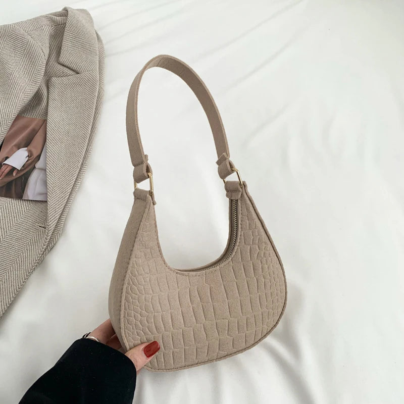 Sac tendance en feutre de haute qualité, au style rétro et élégant. Conçu pour être porté sous le bras ou à l’épaule, il allie simplicité et design moderne.