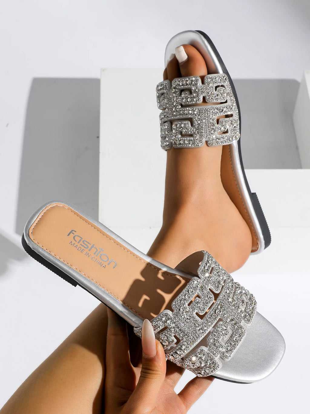 Sandales d’été 2026 pour femme à semelle plate, avec motif géométrique et décorations en diamant. Chaussures de plage polyvalentes et décontractées à enfiler, au style tendance et moderne pour femme.