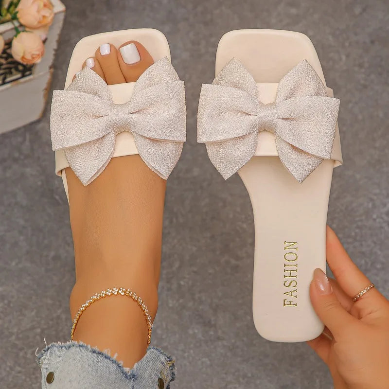 Nouvelles mules plates pour femme 2026, sandales tendance à couleur unie avec nœud décoratif, légères et confortables pour l’extérieur, la plage et un usage quotidien. Disponibles en grandes tailles.