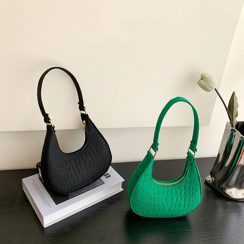 Sac tendance en feutre de haute qualité, au style rétro et élégant. Conçu pour être porté sous le bras ou à l’épaule, il allie simplicité et design moderne.