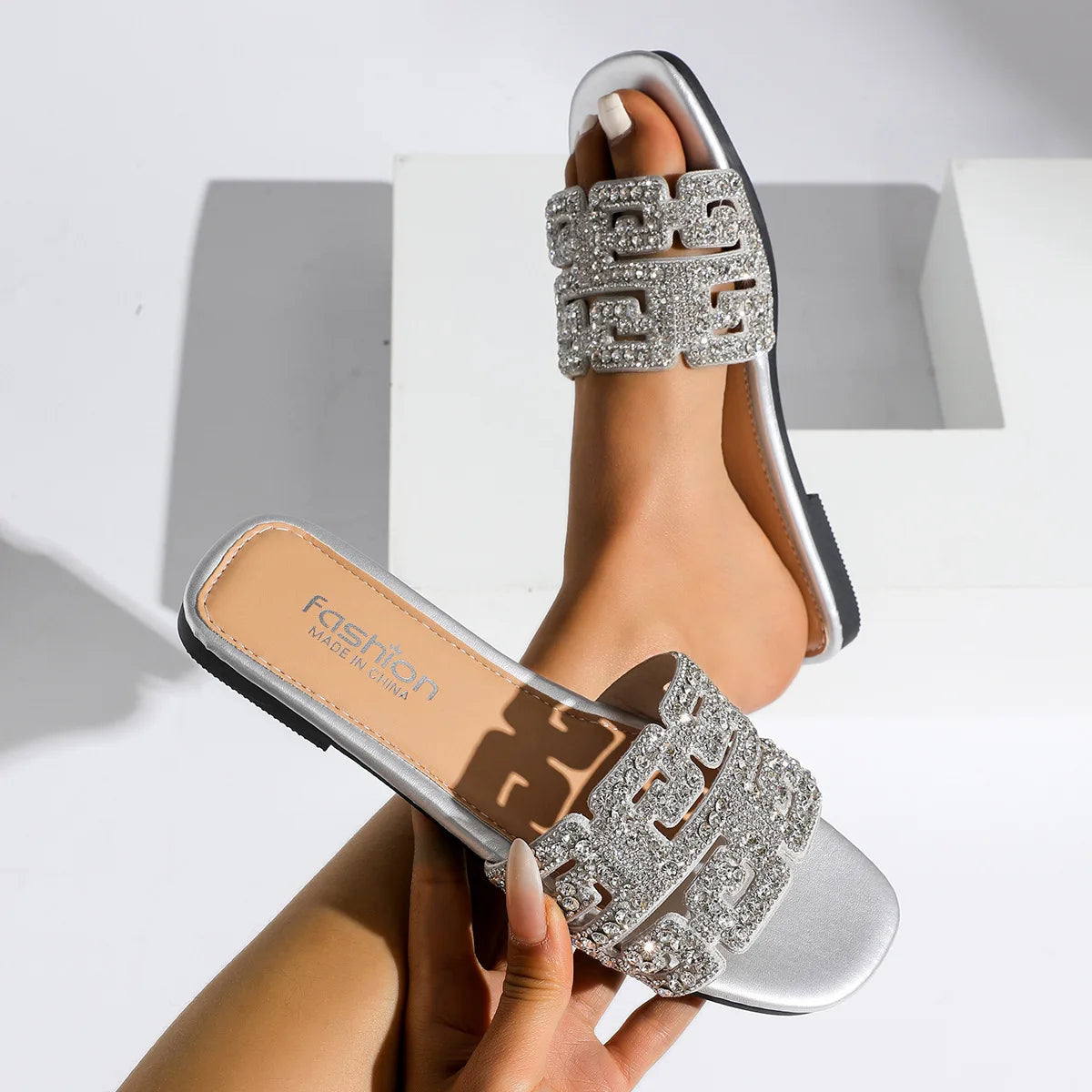 Sandales d’été 2026 pour femme à semelle plate, avec motif géométrique et décorations en diamant. Chaussures de plage polyvalentes et décontractées à enfiler, au style tendance et moderne pour femme.