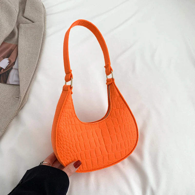Sac tendance en feutre de haute qualité, au style rétro et élégant. Conçu pour être porté sous le bras ou à l’épaule, il allie simplicité et design moderne.