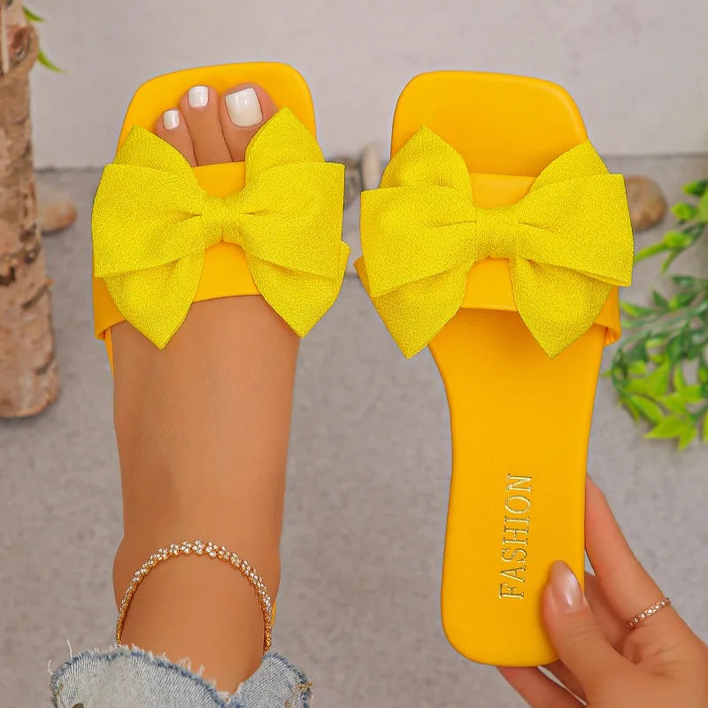 Nouvelles mules plates pour femme 2026, sandales tendance à couleur unie avec nœud décoratif, légères et confortables pour l’extérieur, la plage et un usage quotidien. Disponibles en grandes tailles.