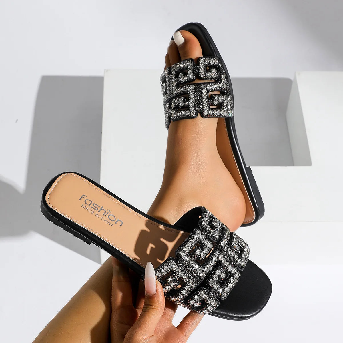 Sandales d’été 2026 pour femme à semelle plate, avec motif géométrique et décorations en diamant. Chaussures de plage polyvalentes et décontractées à enfiler, au style tendance et moderne pour femme.