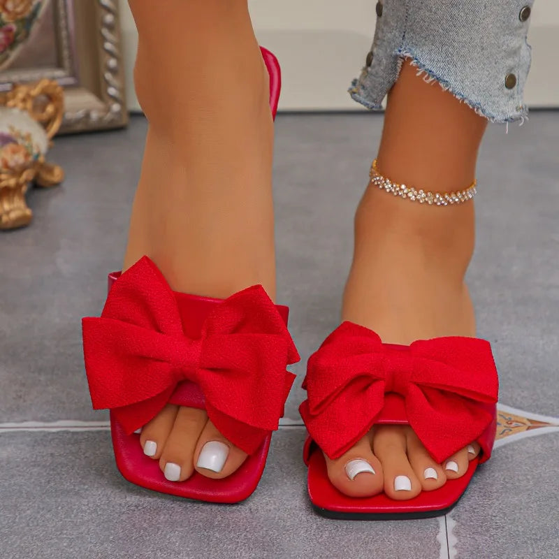 Nouvelles mules plates pour femme 2026, sandales tendance à couleur unie avec nœud décoratif, légères et confortables pour l’extérieur, la plage et un usage quotidien. Disponibles en grandes tailles.