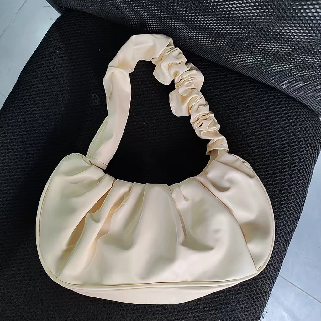 Sac à main élégant au design plissé effet nuage, conçu en cuir PU. Ce modèle moderne et féminin peut être porté à l’épaule ou sous le bras pour un look chic et décontracté.